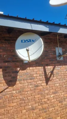 Close view of a dish bracket bolted to a face-brick wall