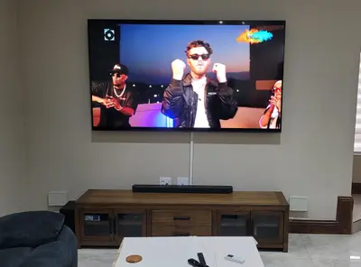 TV wall-mounted above a soundbar in a tidy lounge setup